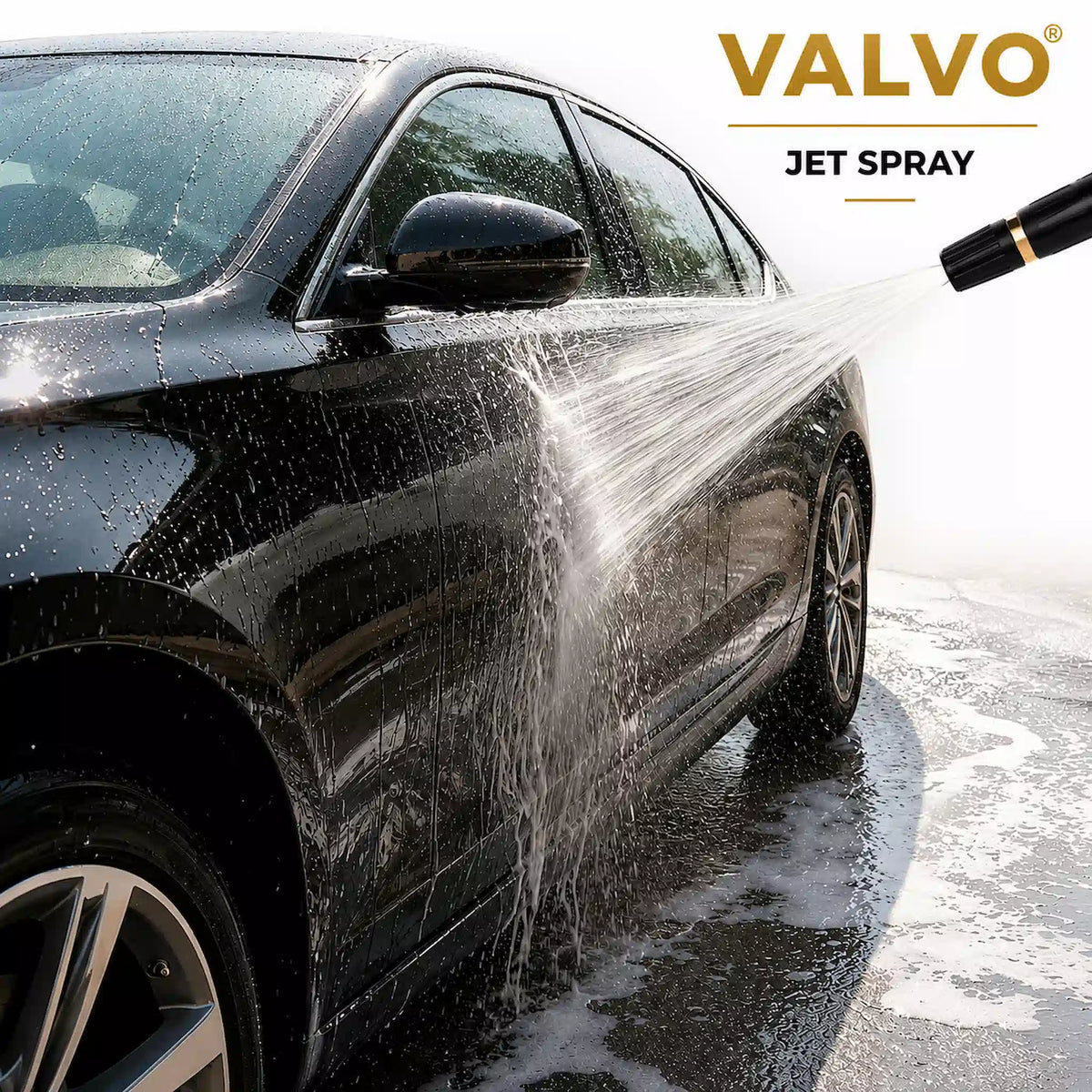 A black car being washed with a powerful jet spray stream from a black hose. The image features the 'VALVO JET SPRAY' logo in the top right corner, set against a bright, high-contrast background with white foam and water droplets.